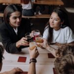 A group of friends raising glasses for a toast in a cozy pub setting, symbolizing friendship and celebration.