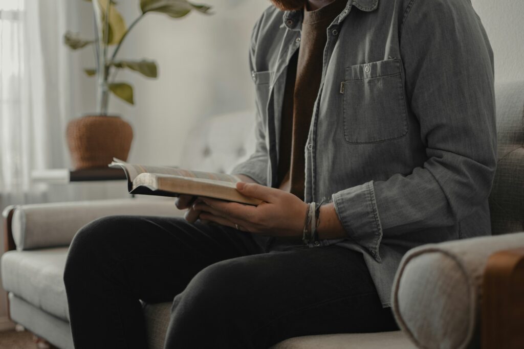 Home 1 woman in blue denim jacket and black pants sitting on couch